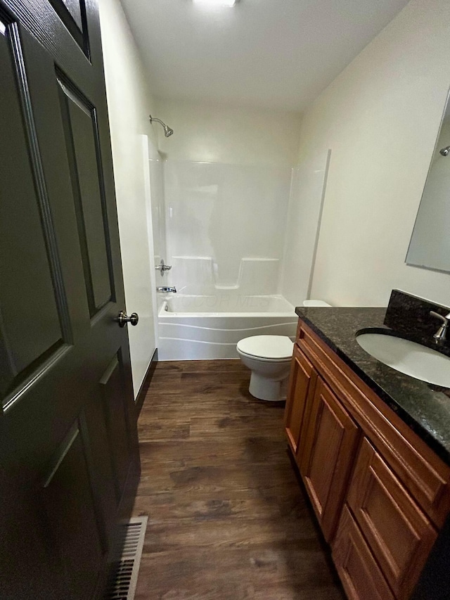 full bathroom featuring vanity, wood-type flooring, shower / bathtub combination, and toilet