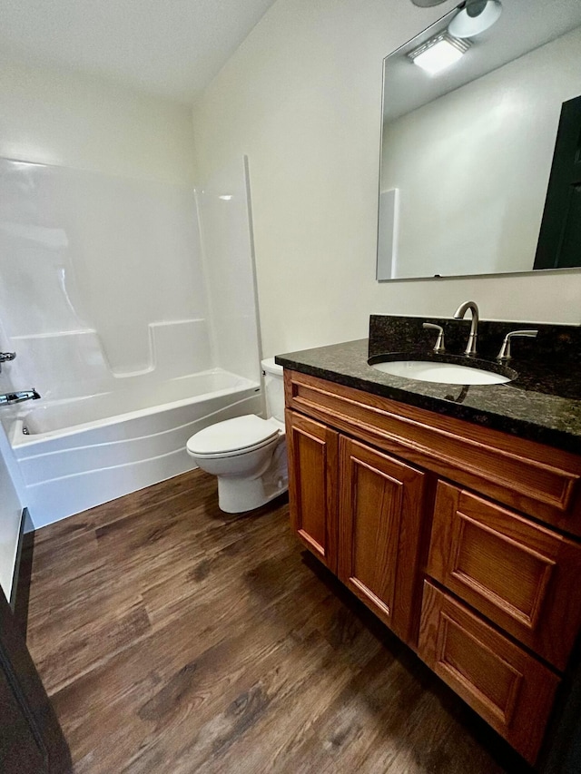 full bathroom with hardwood / wood-style floors, vanity, toilet, and shower / washtub combination