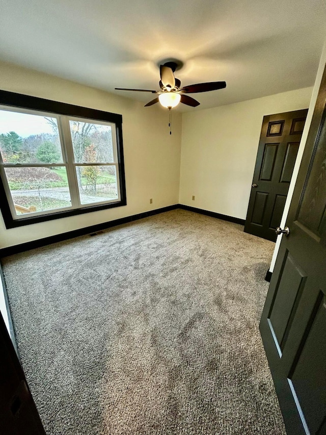 unfurnished room featuring ceiling fan and carpet floors