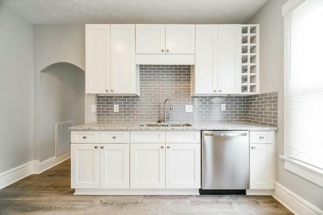 kitchen featuring dishwasher, light wood-type flooring, white cabinets, and sink