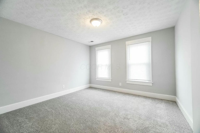 unfurnished room featuring carpet flooring and a textured ceiling