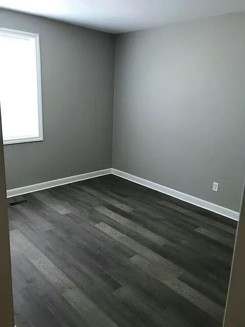 spare room featuring dark hardwood / wood-style flooring