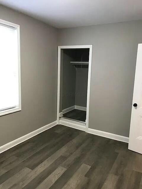 unfurnished bedroom featuring dark hardwood / wood-style floors and a closet