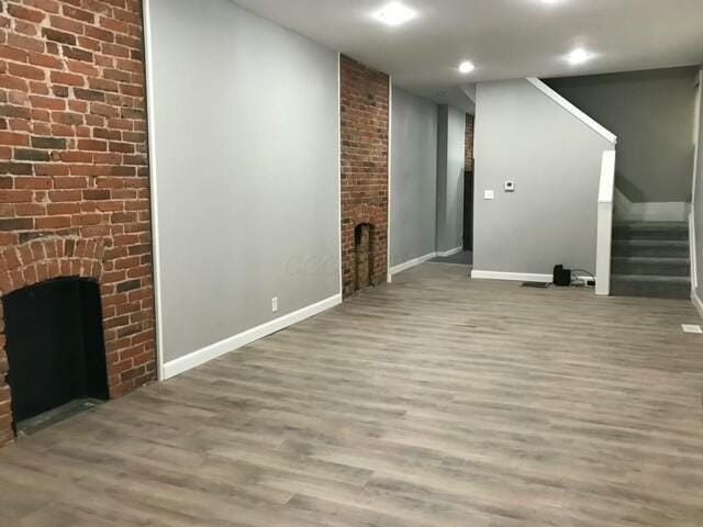 unfurnished living room featuring wood-type flooring and a fireplace