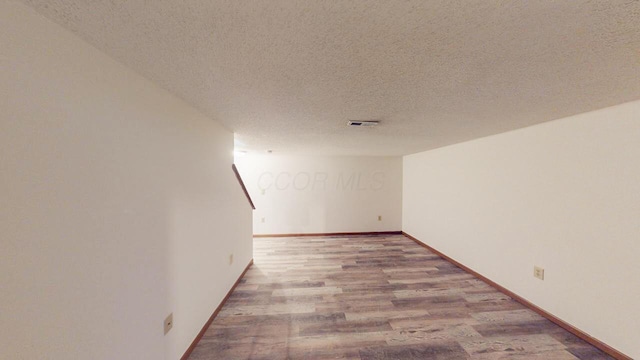 empty room featuring hardwood / wood-style flooring and a textured ceiling