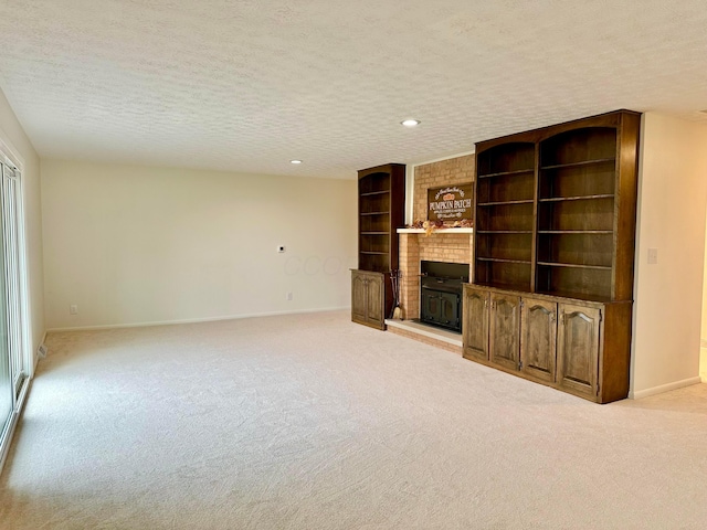 unfurnished living room featuring a textured ceiling, a fireplace, and light carpet