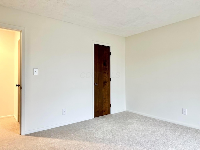 carpeted empty room with a textured ceiling