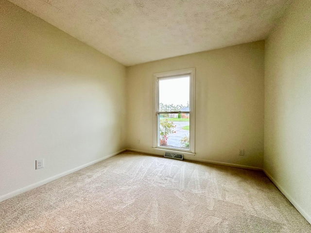 carpeted spare room featuring a textured ceiling