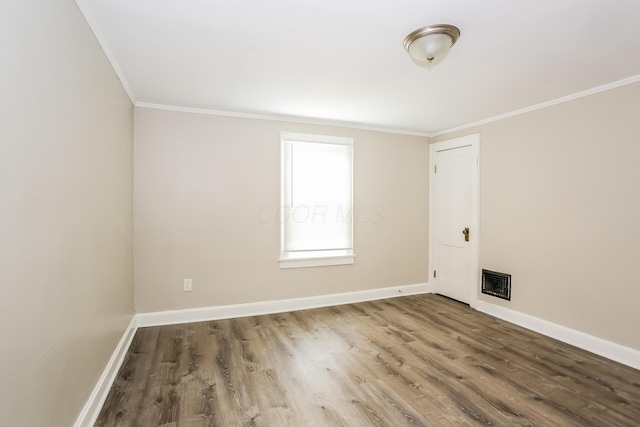 empty room featuring hardwood / wood-style floors and ornamental molding