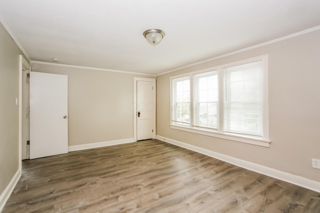 spare room featuring wood-type flooring and ornamental molding