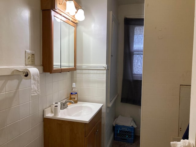 bathroom with tasteful backsplash, vanity, and tile walls