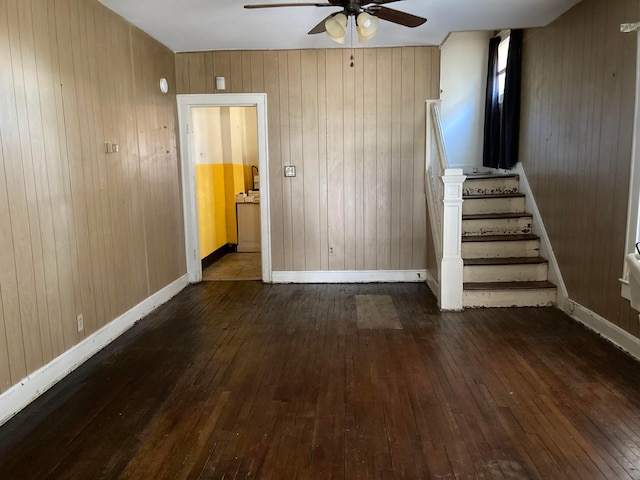 interior space featuring ceiling fan, wood-type flooring, and wood walls