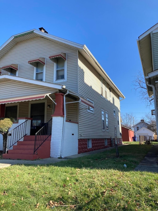 view of side of property featuring a porch and a lawn