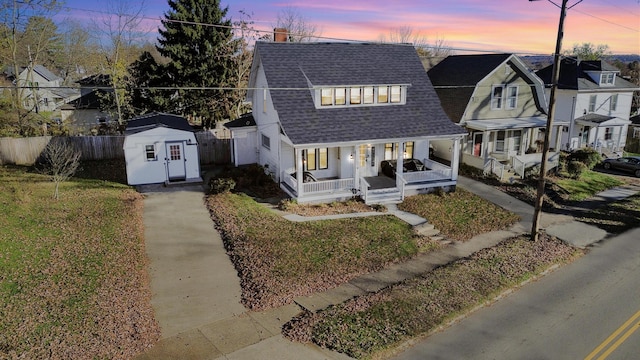 view of front of property with a porch and a storage shed