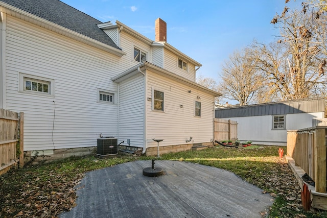 back of property featuring a lawn and central air condition unit