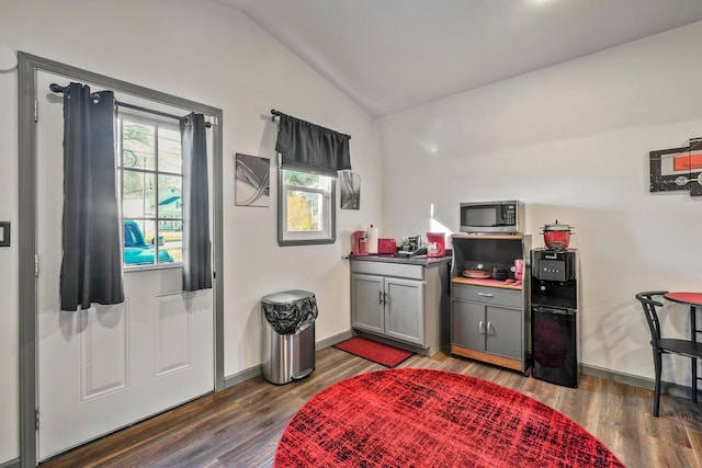 interior space featuring lofted ceiling, dark hardwood / wood-style floors, and gray cabinetry