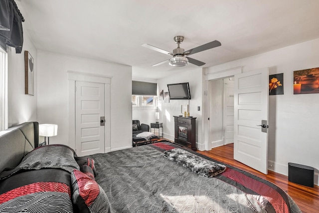 bedroom with a closet, dark hardwood / wood-style floors, and ceiling fan