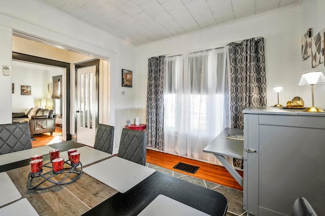 dining area with hardwood / wood-style floors and crown molding