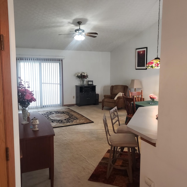 living room with a textured ceiling, ceiling fan, and carpet floors