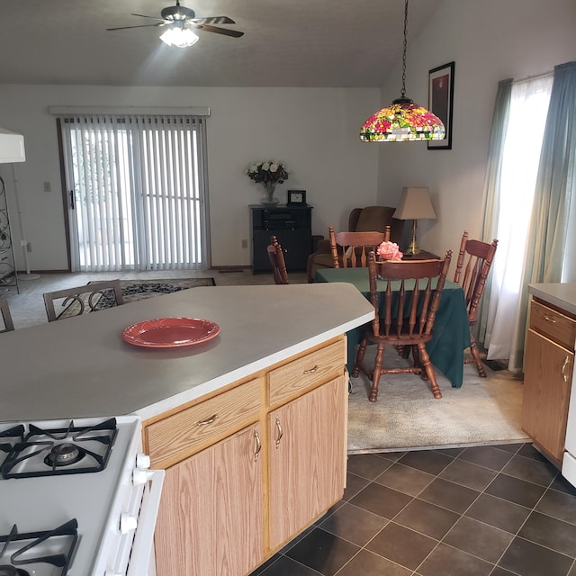 kitchen with decorative light fixtures, dark tile patterned flooring, a wealth of natural light, and light brown cabinets