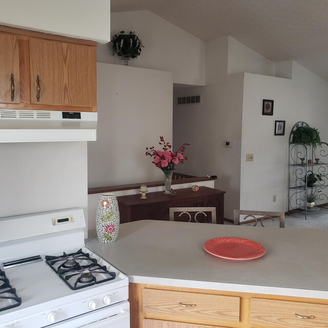 kitchen with white range with gas cooktop and lofted ceiling