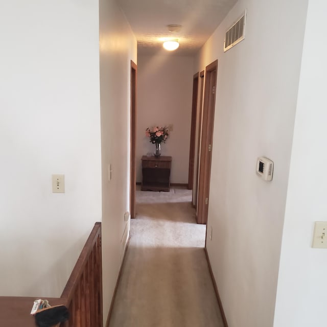 hallway featuring light colored carpet