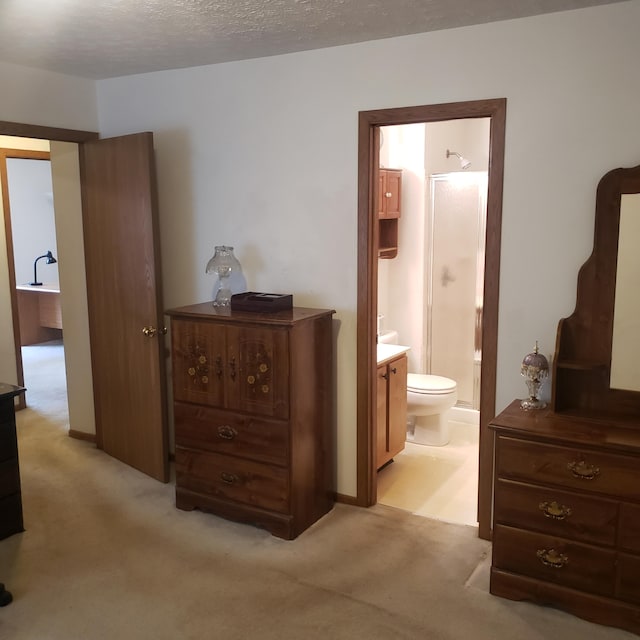 carpeted bedroom with a textured ceiling and ensuite bathroom