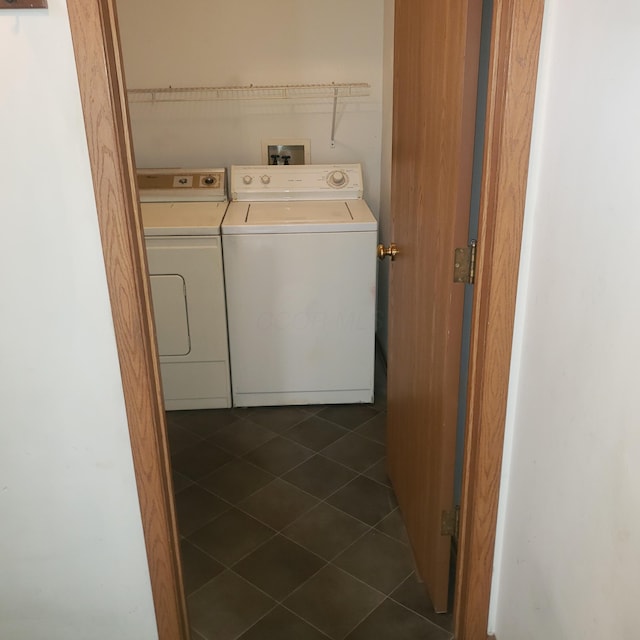 laundry area with washer and clothes dryer and dark tile patterned flooring