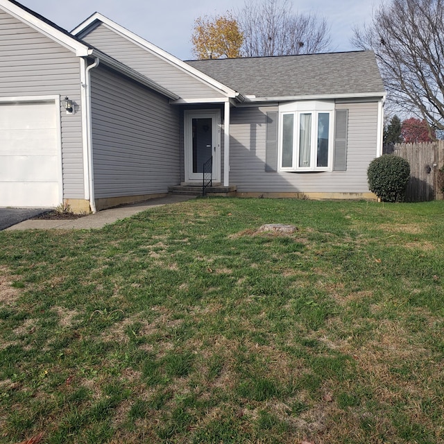 ranch-style house featuring a garage and a front lawn