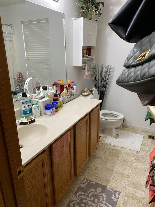 bathroom featuring tile patterned flooring, vanity, and toilet