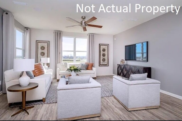 living room featuring baseboards, wood finished floors, and a ceiling fan