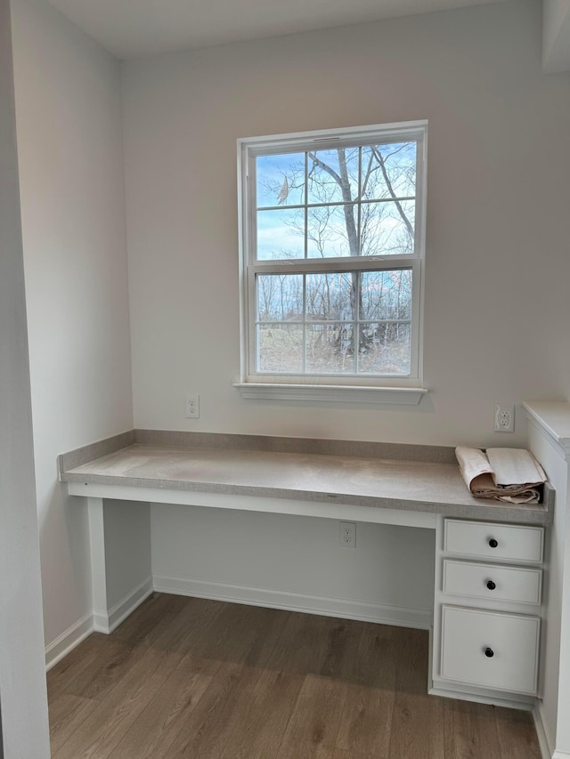 unfurnished office with wood-type flooring and built in desk