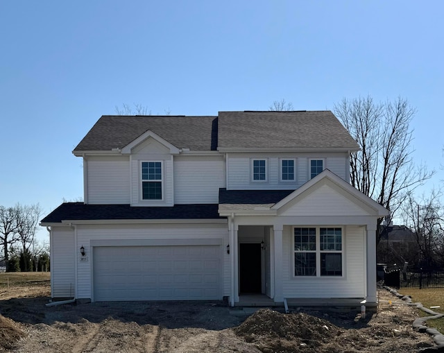 view of front of home with driveway, a garage, and roof with shingles