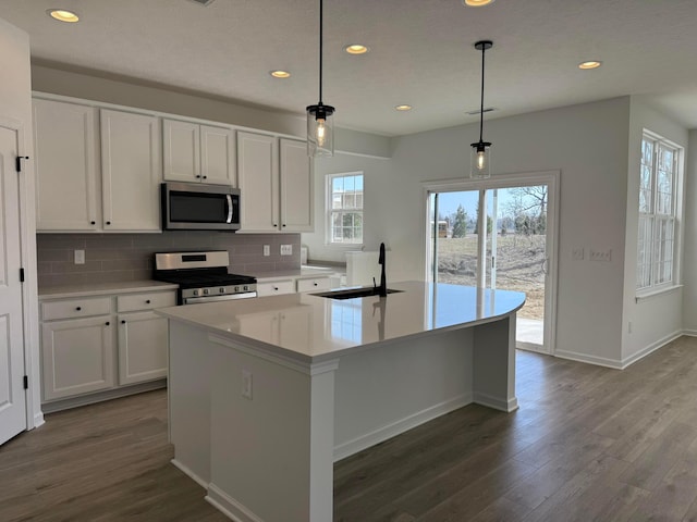 kitchen featuring a sink, dark wood-type flooring, white cabinets, appliances with stainless steel finishes, and tasteful backsplash