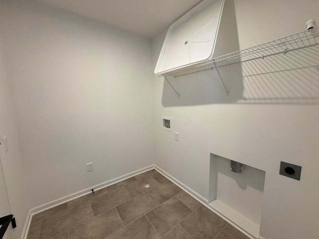 washroom with baseboards, hookup for an electric dryer, hookup for a washing machine, and laundry area