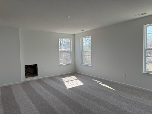 spare room featuring visible vents, baseboards, and carpet floors