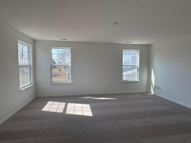 empty room with visible vents, baseboards, and carpet floors