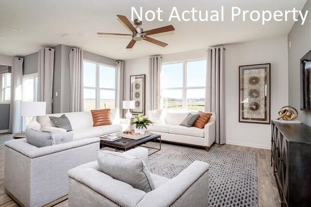 living room with light wood-style flooring, plenty of natural light, and a ceiling fan