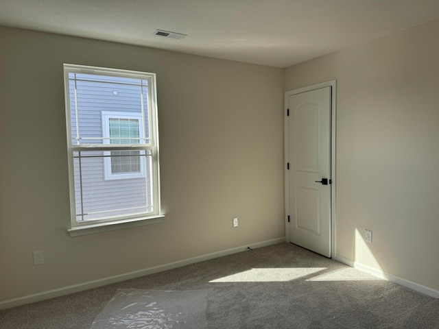 spare room featuring visible vents, baseboards, and carpet floors