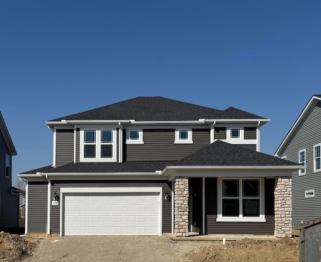 view of front of home with driveway, a garage, stone siding, and roof with shingles