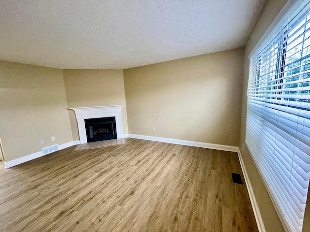 unfurnished living room featuring wood-type flooring and a textured ceiling