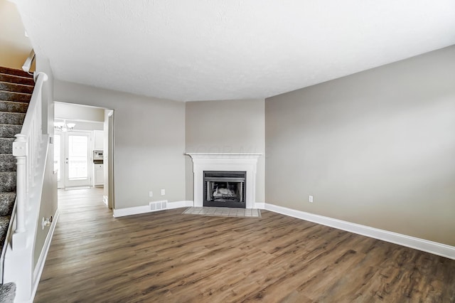 unfurnished living room featuring dark hardwood / wood-style flooring and a textured ceiling