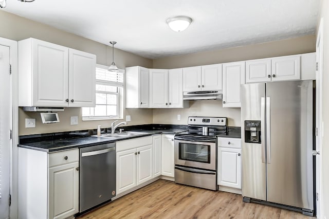 kitchen featuring sink, hanging light fixtures, stainless steel appliances, light hardwood / wood-style floors, and white cabinets