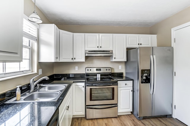 kitchen featuring sink, white cabinetry, decorative light fixtures, light wood-type flooring, and appliances with stainless steel finishes