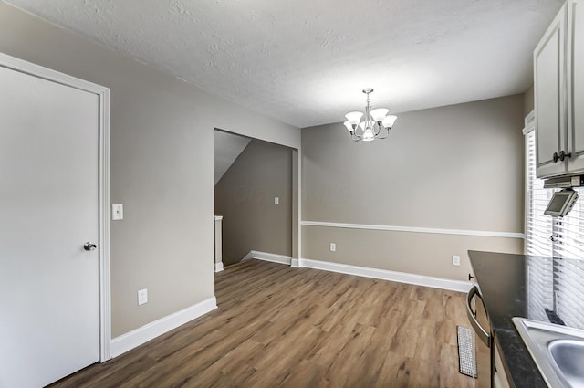 interior space featuring wood-type flooring, a chandelier, sink, and a textured ceiling