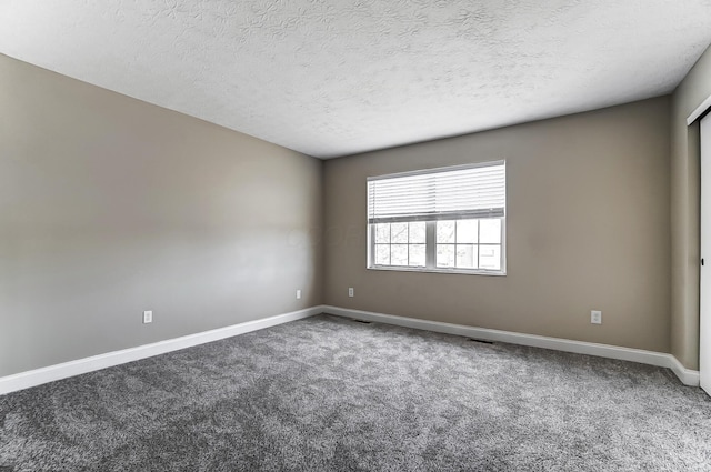 carpeted spare room featuring a textured ceiling