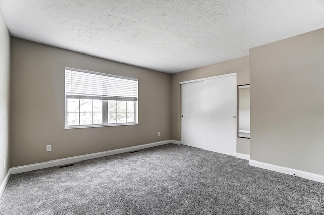 unfurnished bedroom with a closet, a textured ceiling, and carpet