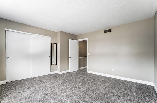 unfurnished bedroom with carpet floors, a textured ceiling, and a closet