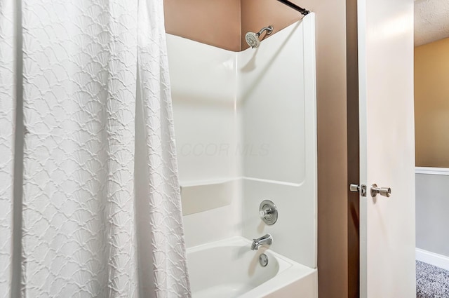 bathroom featuring shower / bath combination with curtain and a textured ceiling