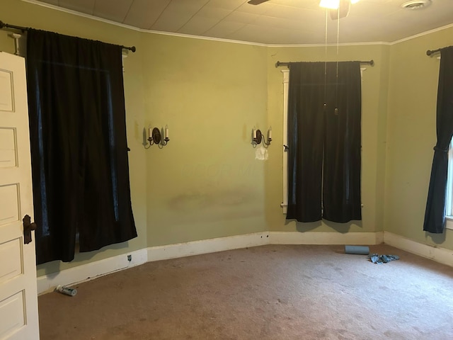 carpeted spare room featuring crown molding and ceiling fan